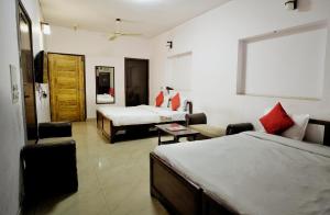 a hotel room with two beds and a living room at Ashu Villa in New Delhi