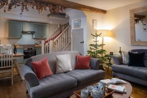 a living room with a couch and a christmas tree at Hop Pickers Cottage in Little Marcle