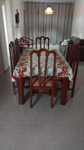 a dining room table and chairs with a floral table and chairsktop at Apê Ponta da Praia Santos in Santos