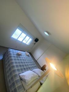 a small room with a bed with a window at Apê Ponta da Praia Santos in Santos
