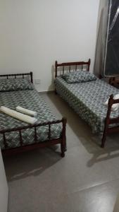 two beds sitting next to each other in a room at Apê Ponta da Praia Santos in Santos