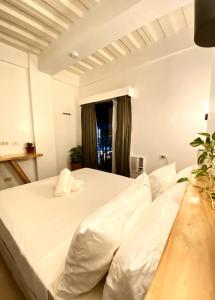 a bedroom with two white beds and a window at Ahava Boutique Hotel in Pooc +9 photos