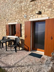 a patio with a table and chairs next to a stone building at Agriturismo El Bocolar in Marano di Valpolicella +16 photos