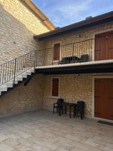a patio with a table and chairs next to a building at Agriturismo El Bocolar in Marano di Valpolicella
