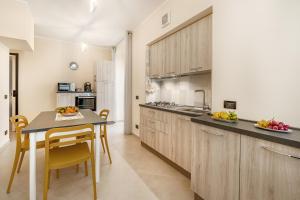 a kitchen with wooden cabinets and a table and chairs at Busacca Suite in Scicli