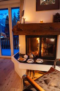 a living room with a fireplace with food on a table at Casa Nonna in Lenzerheide