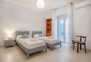 a bedroom with two beds and a table and a chair at Busacca Suite in Scicli