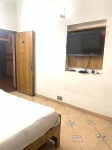 a room with a flat screen tv on a wall at Ashu Villa in New Delhi