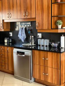 a kitchen with wooden cabinets and a stainless steel dishwasher at Casa Mia in Jeffreys Bay
