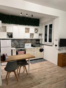 a kitchen with white cabinets and a wooden table at Swinburne in Genoa