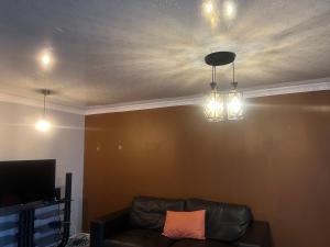 a living room with a couch and lights on a ceiling at Oryx guest house in Oakdale