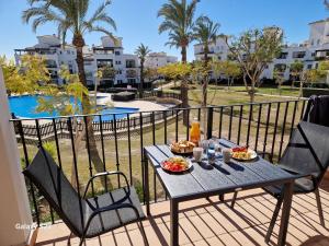 a table with food on a balcony with a view of a pool at Donna Olympia's House in Sucina