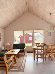 a living room with a couch and a table and chairs at Nobel Cabins - Furillen in Lärbro