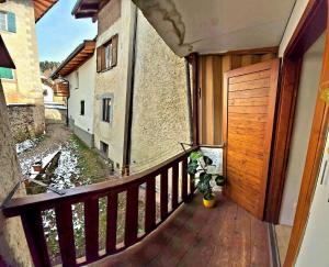a balcony with a wooden door and a potted plant at Maison Cavalese - Polar Express in Cavalese