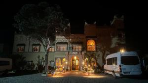 a white van parked in front of a building at night at Hotel Soleil Blue in Boumalne Dades