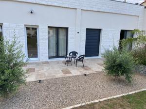 a patio with two chairs and a table in front of a house at Chambre double centre ville Bergerac in Bergerac +4 photos