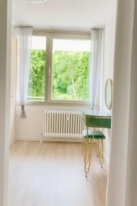 a white room with a table and a window at Apartment Ypsilon am Grün in Bayreuth +9 photos
