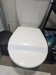 a white toilet seat with a sign on it at Mobile home Jadre I in Pakoštane
