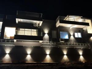 a building with lights on the side of it at night at Casa Oceanus - Sea Facing Forest View Room - Ganpatipule in Nevra