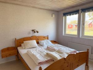 a bedroom with a wooden bed with two pillows at Nobel Cabins - Furillen in Lärbro