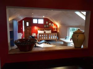 a room with a kitchen and a bedroom with red walls at The Village Studio Apartments in Moate