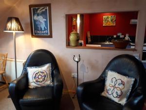 two black leather chairs in a living room at The Village Studio Apartments in Moate