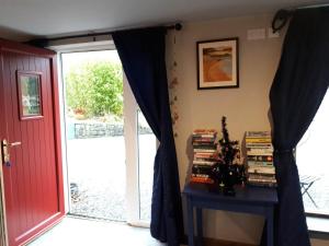 a room with a door and a table with books at The Village Studio Apartments in Moate +9 photos