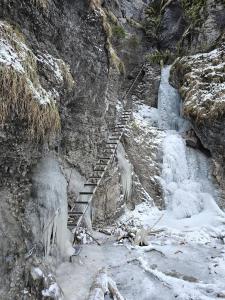 a snow covered mountain with a staircase next to a waterfall at Domček Michal in Hrabušice
