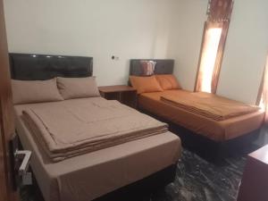 a room with two beds and a bed and a window at Safira in Ngadisari