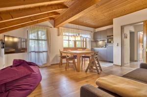 a kitchen and living room with a table and chairs at Landhaus Lerchenweg FeWo inkl aktivCARD in Neuschönau