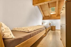 two beds in a small room with wooden ceilings at Landhaus Lerchenweg FeWo inkl aktivCARD in Neuschönau