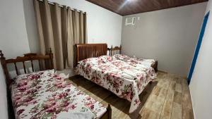 two beds in a small room with a bedskirts at Vale das Rainhas Pousada Santo Amaro BA in Santo Amaro