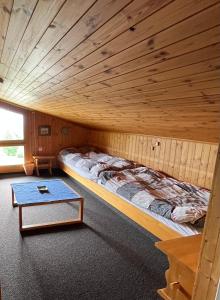a bed in a room with a wooden ceiling at Chalet Heide Beatenberg in Beatenberg