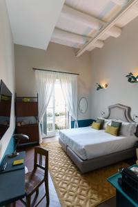 a bedroom with a bed and a desk and a window at Accademia 39 in Sorrento