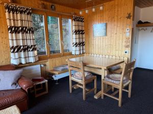 a room with a table and chairs and a couch at Chalet Heide Beatenberg in Beatenberg