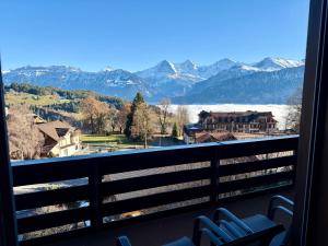 a balcony with chairs and a view of the mountains at Chalet Heide Beatenberg in Beatenberg