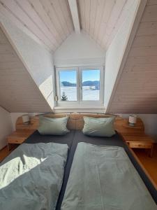 a bed in a room with two pillows and a window at Ferienhaus am Hang in Bad Wurzach