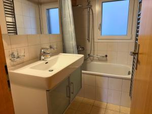 a bathroom with a sink and a bath tub at Chalet Heide Beatenberg in Beatenberg +28 photos