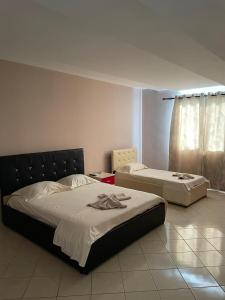 een slaapkamer met twee bedden en een raam bij Bar Hotel Orgito in Lushnjë