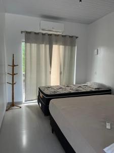 a bedroom with two beds and a window at Chácara Fim de Tarde in Barra do Garças +25 photos