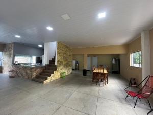 a living room with chairs and a table and a kitchen at Chácara Fim de Tarde in Barra do Garças
