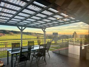 a table and chairs on a balcony with a view at Ferienhaus am Hang in Bad Wurzach