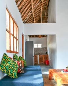 a living room with a blue couch and a table at Ushongo Beach Bandas in Pangani