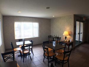a dining room with tables and chairs and a window at Super 8 by Wyndham Canandaigua in Canandaigua