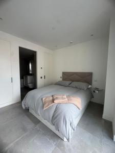 a white bedroom with a large bed in it at VV - Skyline Studio Pool & Gym in City Centre in Gibraltar +8 photos