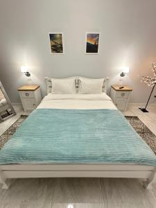 a bedroom with a large bed with two night stands at Апартаменти La Storia in Kamianets-Podilskyi
