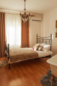 een slaapkamer met een bed met een kroonluchter bij Chic&Vrdnik in Vrdnik