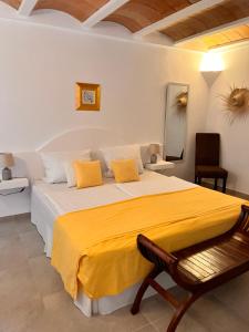 a bedroom with a large bed with a yellow blanket at Villa Imperial in Cala d´Or +29 photos
