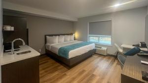 een hotelkamer met een bed en een wastafel bij Studio 6 Fort Frances ON in Fort Frances +23 foto's