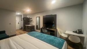 een kamer met een bed, een bureau en een televisie bij Studio 6 Fort Frances ON in Fort Frances